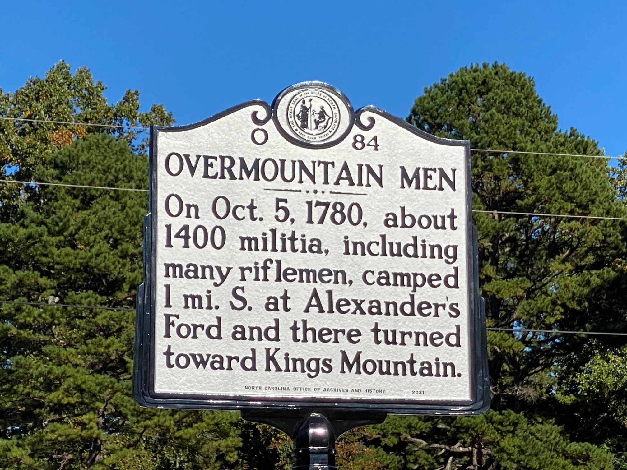 Metal sign discussing a camp of the overmountain men. Gray metal sign with black writing. 